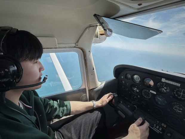 At the controls of a small airplane above the coast